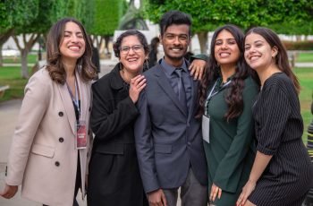 A group of diverse colleagues smiling together, showcasing teamwork and friendship outdoors.